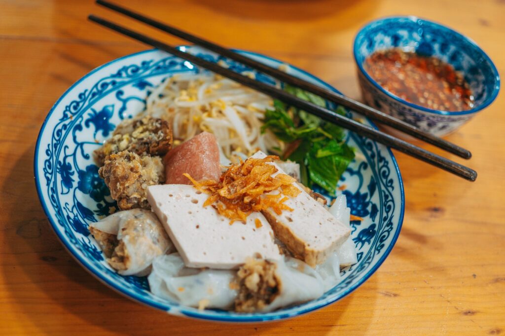 Délicieux plat de riz vietnamien avec du porc, des herbes et une sauce à tremper.