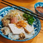 Délicieux plat de riz vietnamien avec du porc, des herbes et une sauce à tremper.
