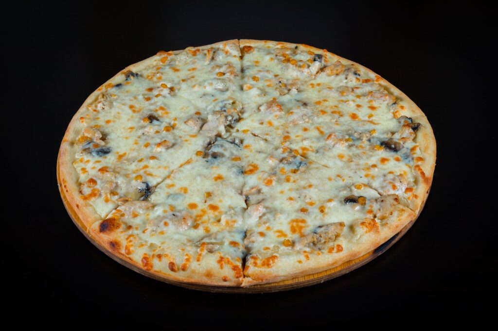 Gros plan sur une délicieuse pizza aux champignons et au fromage sur un fond sombre, parfaitement cuite.