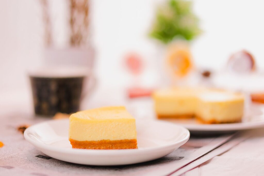Une délicieuse part de cheesecake crémeux sur une assiette avec un arrière-plan flou.