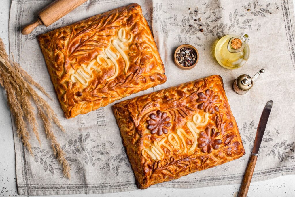 Pies artistiques faites maison avec des designs complexes et des croûtes décoratives pour une photographie vintage de nourriture.