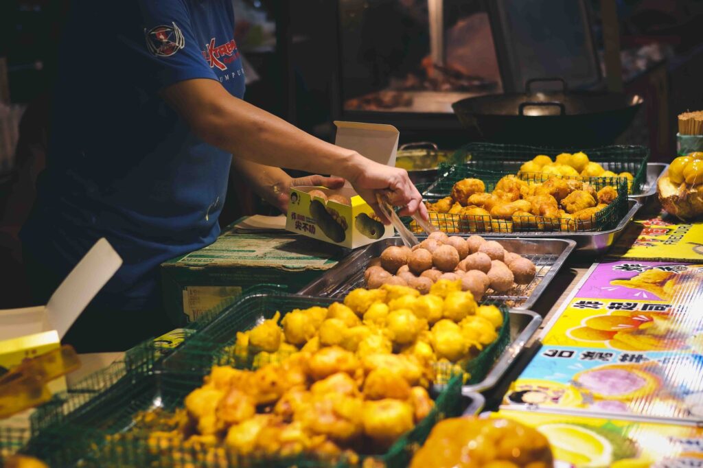 Un stand de nourriture animé au marché de nuit présentant une variété de délicieux snacks frits.