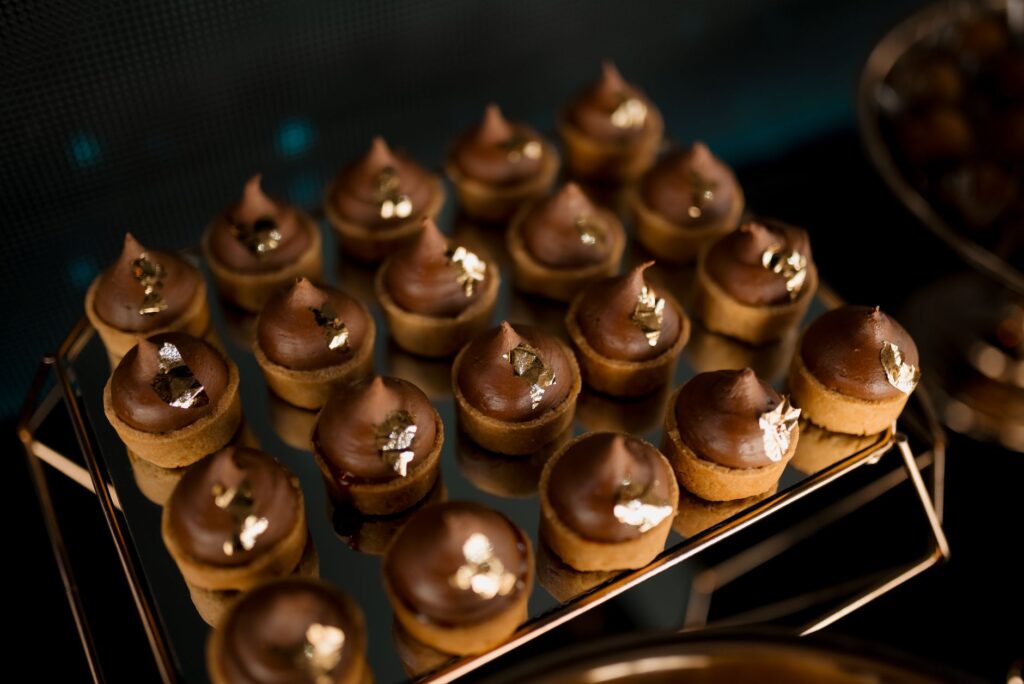 Gros plan sur des desserts au chocolat luxueux ornés de feuilles d'or, parfaits pour des occasions élégantes.