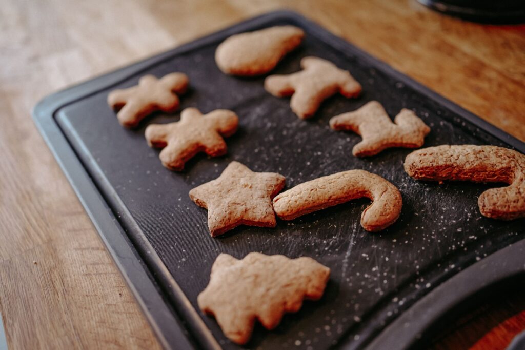 Image en gros plan de biscuits de pain d'épices de Noël fraîchement cuits refroidissant sur un plateau.