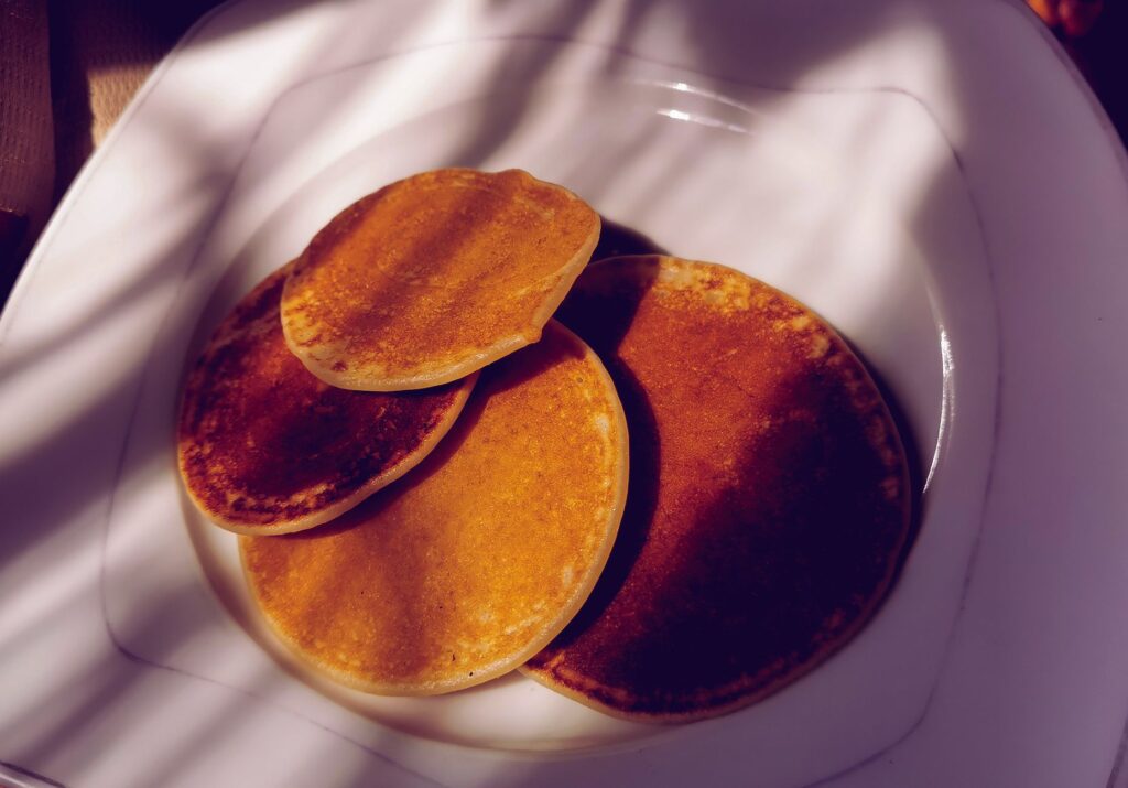 Crêpes dorées sur une assiette blanche, prêtes à être dégustées à tout moment de la journée.