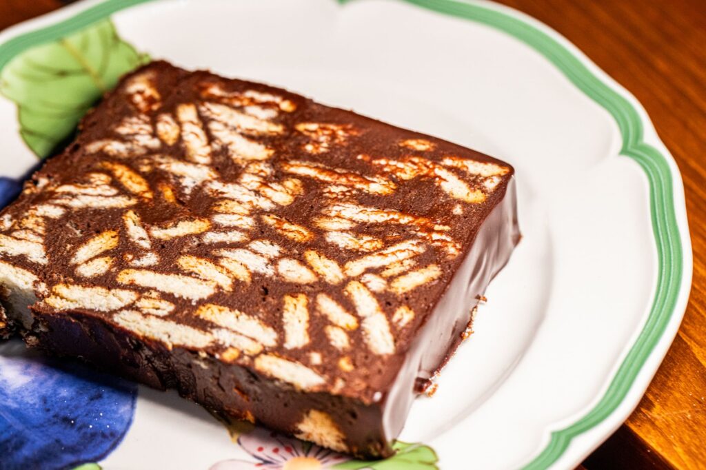 Gâteau aux biscuits au chocolat riche sur une assiette florale, parfait pour les amateurs de desserts.