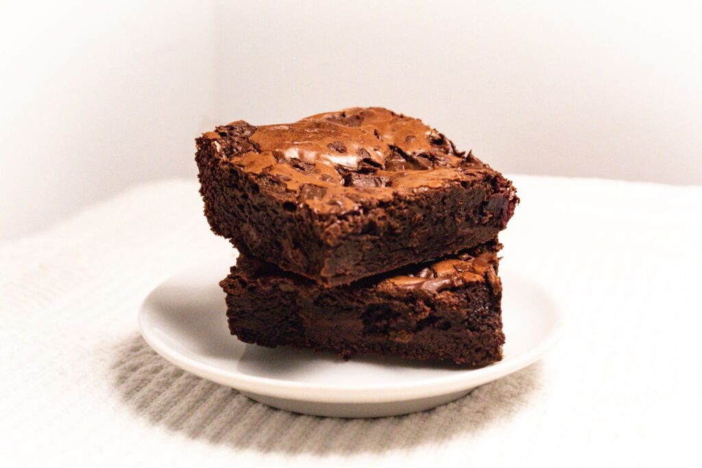 Riches et fondants, ces brownies sont empilés sur une assiette, parfaits pour les amateurs de dessert.