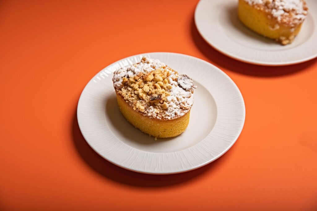 Muffin simple et appétissant avec garniture émiettée sur une assiette blanche sur fond orange.