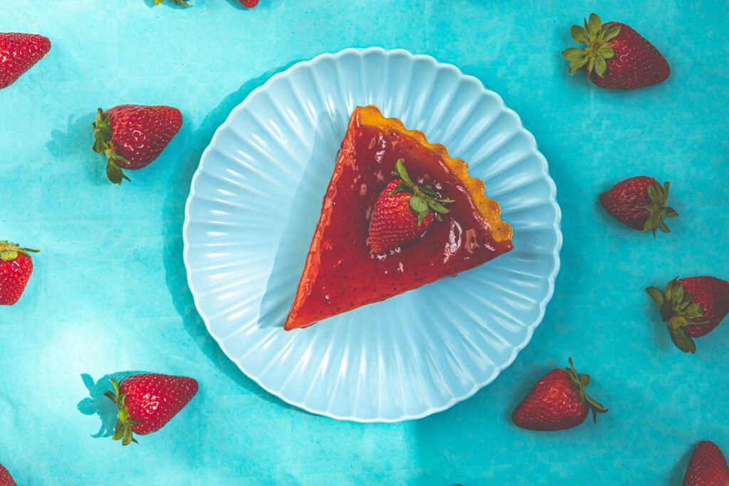 Délicieuse tranche de cheesecake aux fraises sur une assiette blanche avec des fraises fraîches.