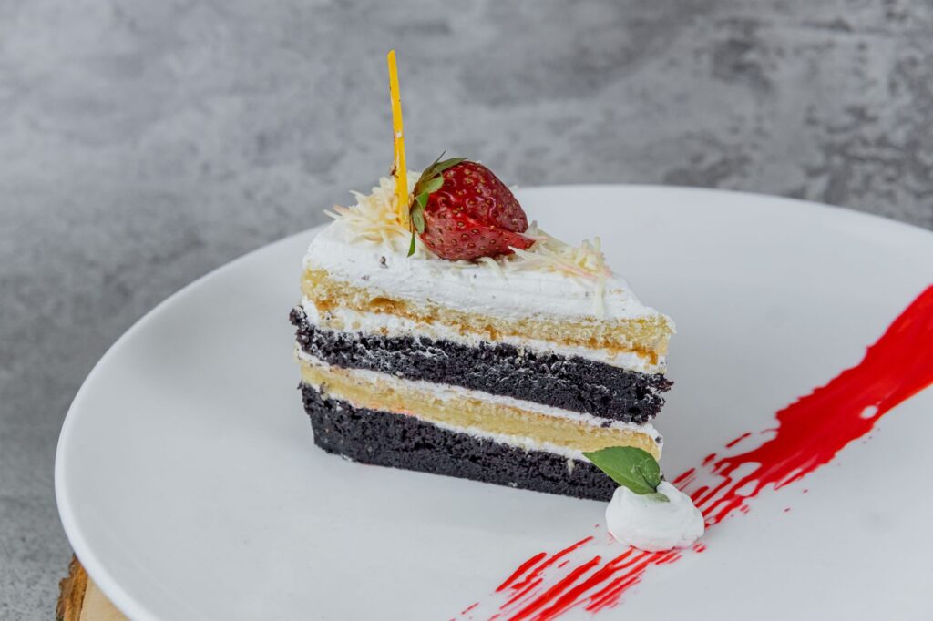 Délicieuse tranche de gâteau au chocolat et à la vanille garnie de fraise.