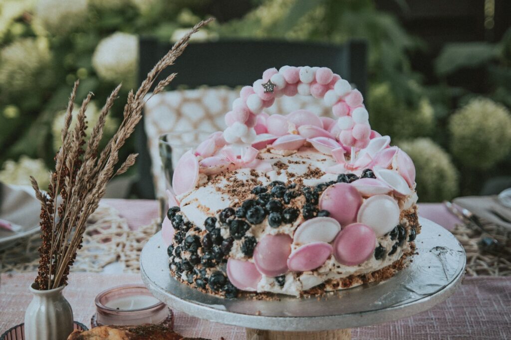 Un gâteau stylé décoré de baies et de meringues, idéal pour des événements en plein air en Pologne.