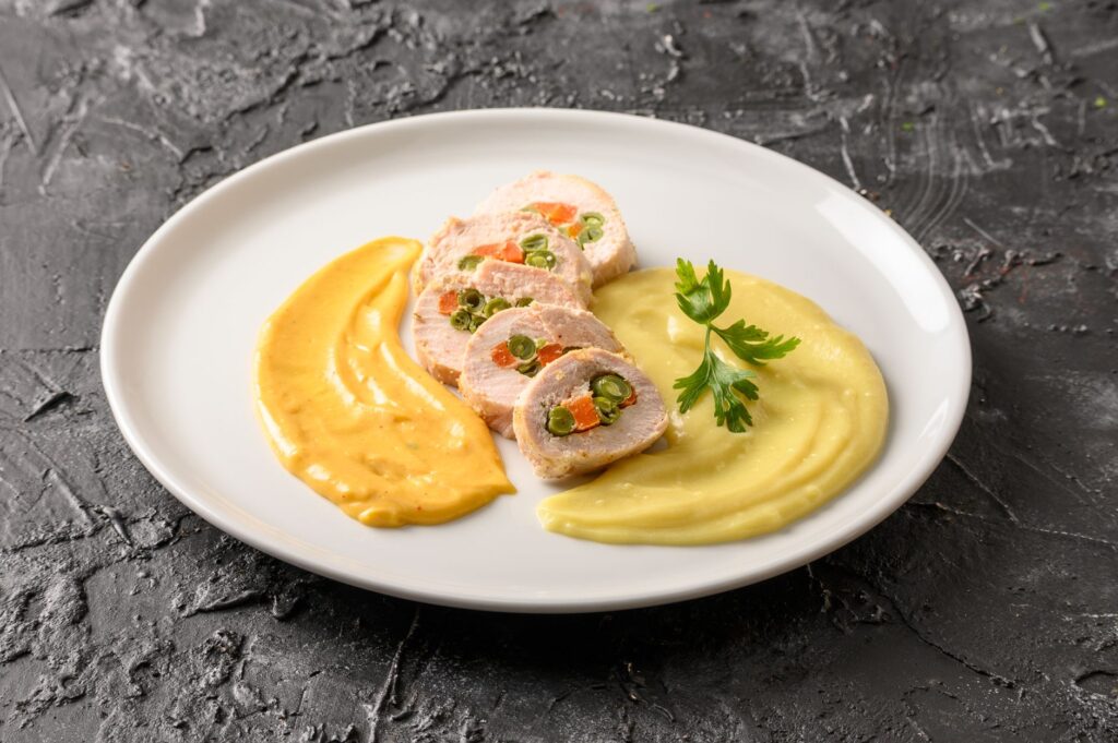 Plat de poulet péruvien exquis garni de purées et de légumes, capturant l'essence de la gastronomie.