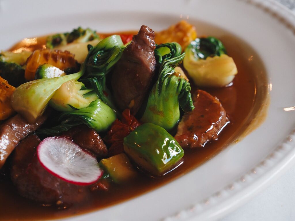 Gros plan d'un sauté asiatique savoureux avec un assortiment de légumes et de viande, garni de sauce.