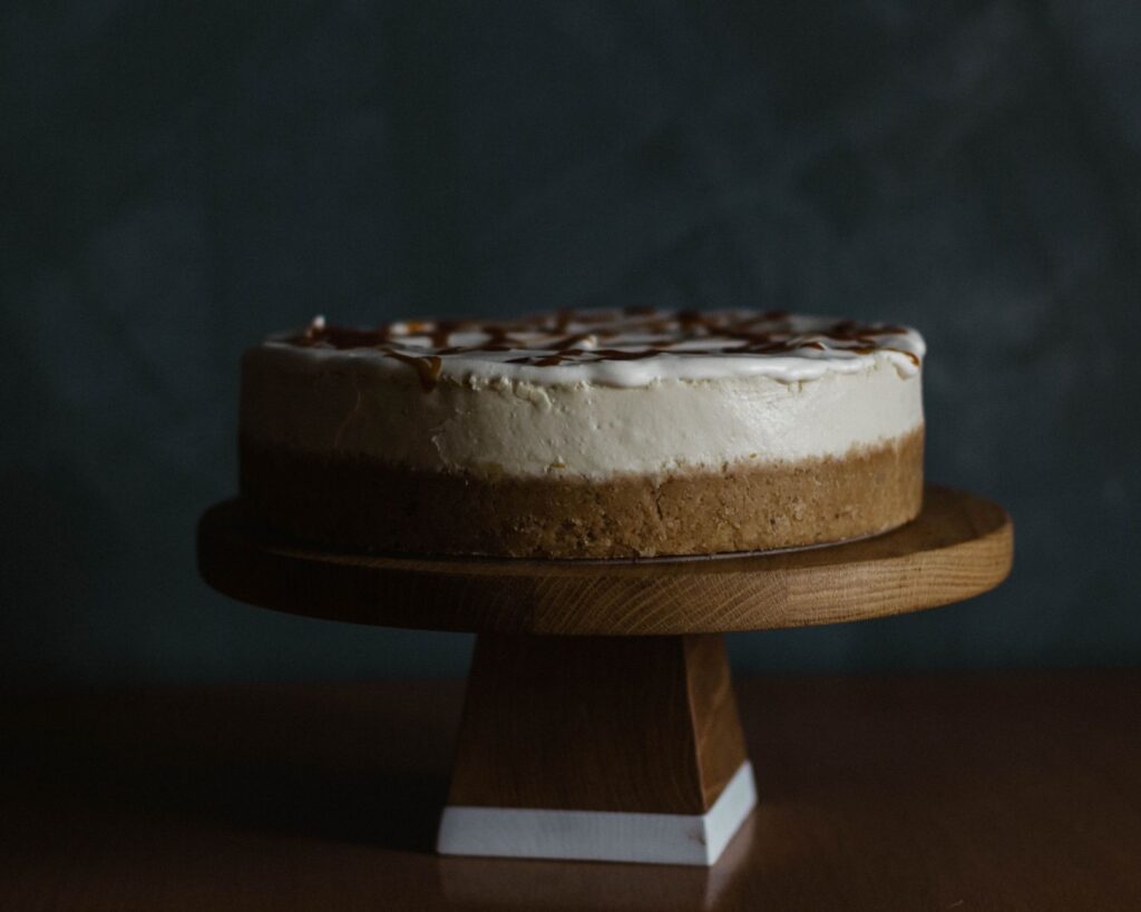 Cheesecake appétissant avec un nappage au caramel sur un présentoir en bois, parfait pour les amateurs de dessert.