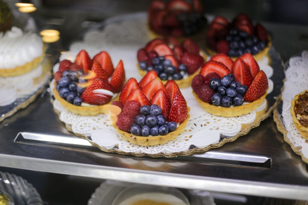 Exposition alléchante de tartelettes aux fruits surmontées de fraises, myrtilles et framboises.