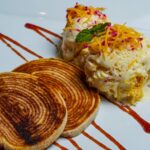 Un dessert gourmet présenté délicieusement avec de la glace, du pain torsadé et une sauce décorative.