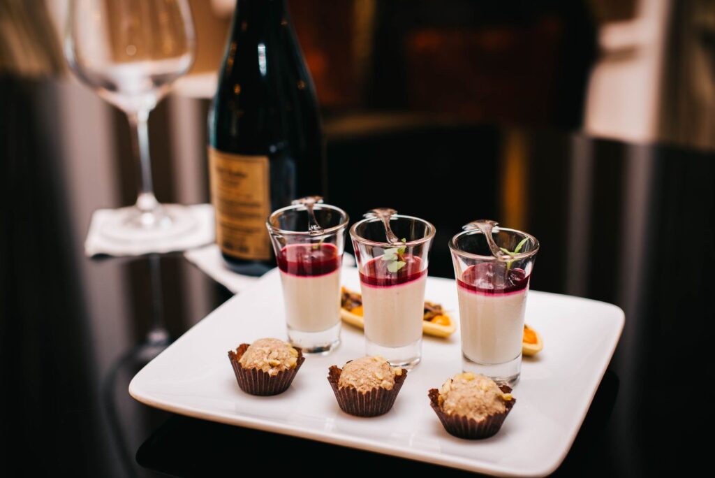 Présentation élégante d'un dessert avec une bouteille de vin dans un cadre gastronomique.