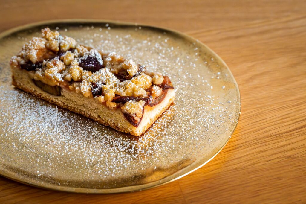 Savourez ce gâteau streusel irrésistible, garni de fruits et délicatement saupoudré de sucre.