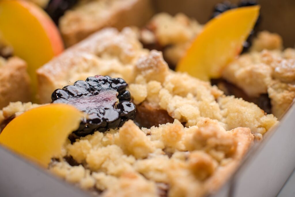 Délicieux gros plan de crumble à la mûre et à la pêche avec croûte dorée.