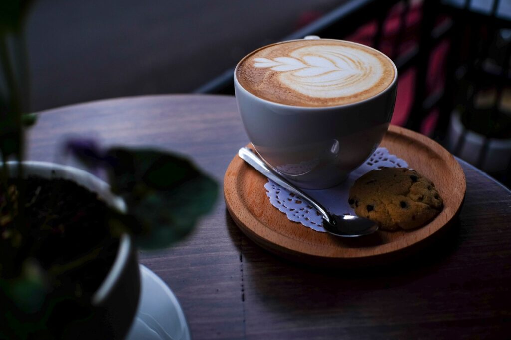 Un cappuccino élégant décoré de latte art, servi avec un biscuit à Nha Trang, au Vietnam.