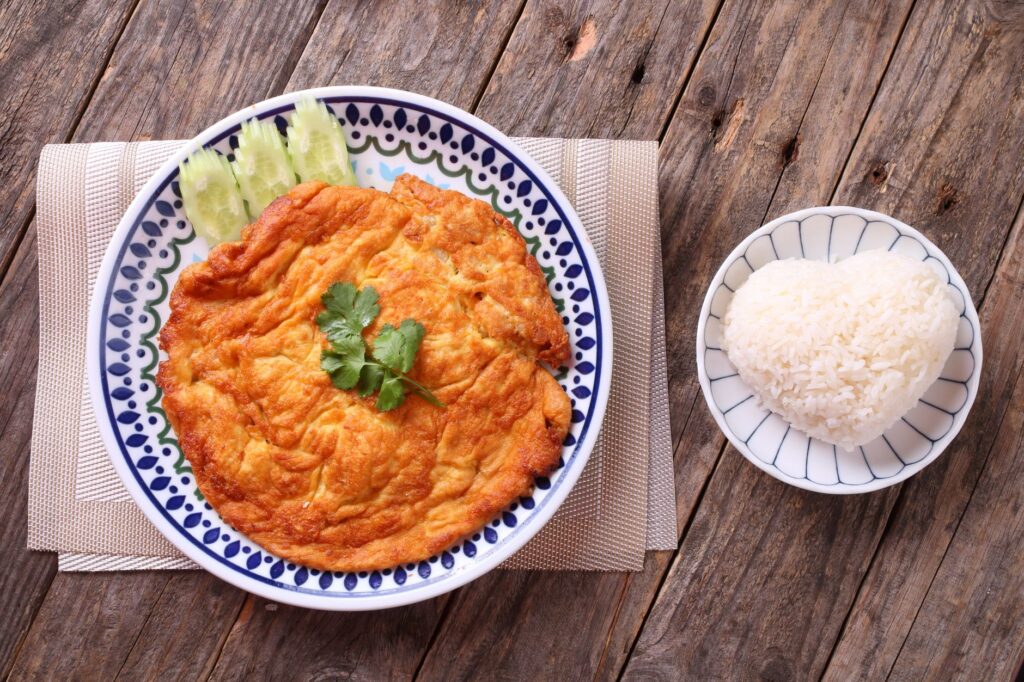 Délicieuse omelette à la thaïlandaise servie avec du riz en forme de cœur pour une touche créative.