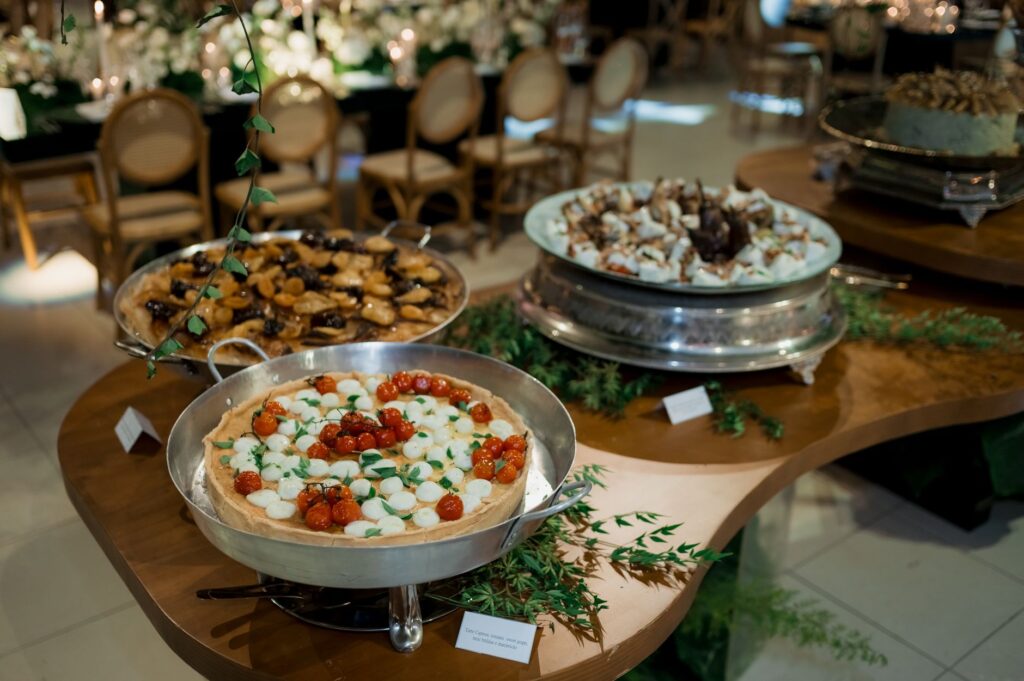 Un élégant assortiment de tartes présenté sur une table de buffet décorative lors d'un événement en intérieur.