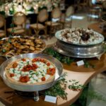 Un élégant assortiment de tartes présenté sur une table de buffet décorative lors d'un événement en intérieur.