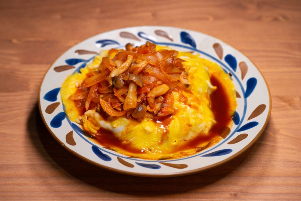 Savourez le goût de l'omurice à la sauce aux champignons dans ce plat japonais appétissant.