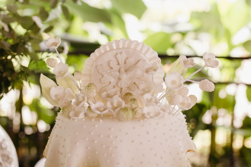 Magnifique gâteau de mariage blanc décoré de motifs floraux, idéal pour les mariages à thème.