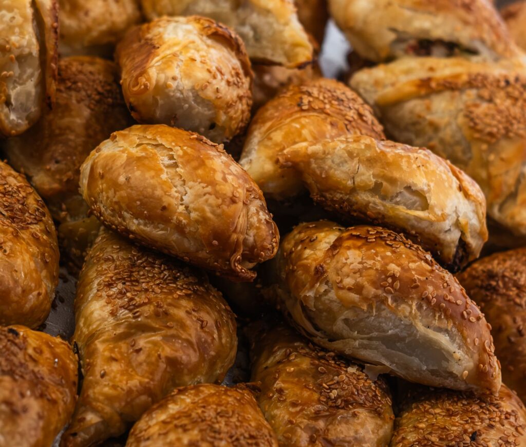 Gros plan de délicieuses pâtisseries turques börek garnies de graines de sésame, fraîches et dorées.