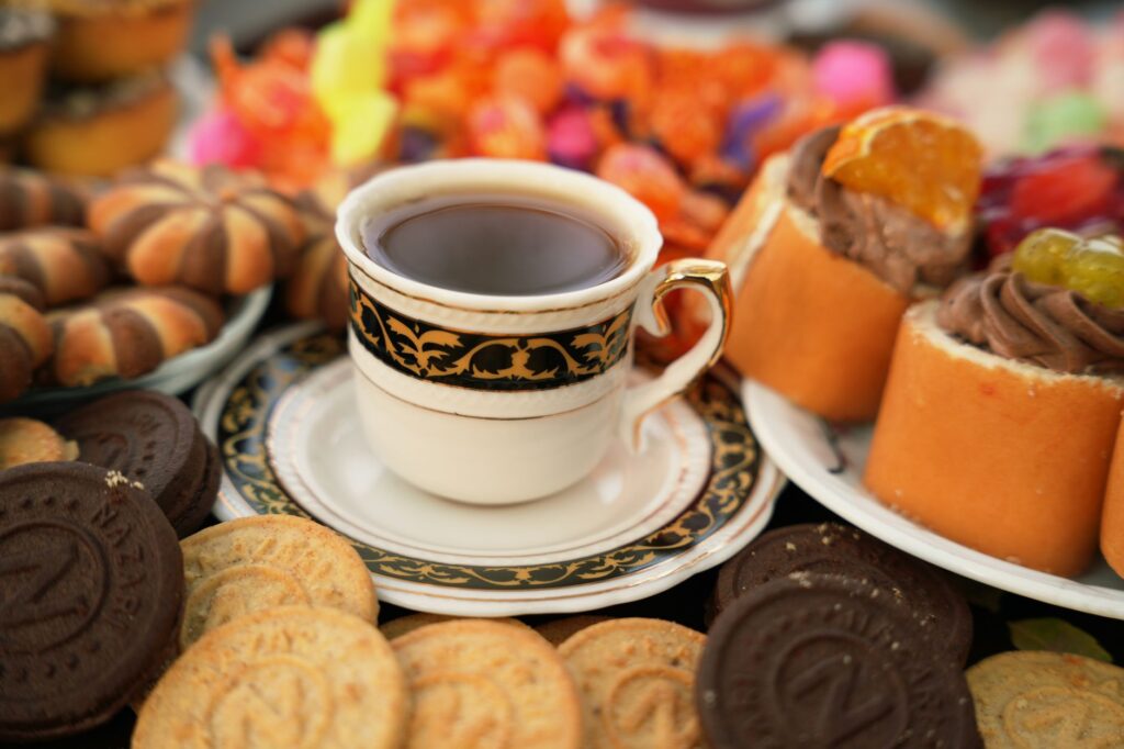 Un élégant service de thé de l'après-midi avec un assortiment de pâtisseries et une tasse et une soucoupe décoratives.