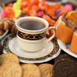 Un élégant service de thé de l'après-midi avec un assortiment de pâtisseries et une tasse et une soucoupe décoratives.