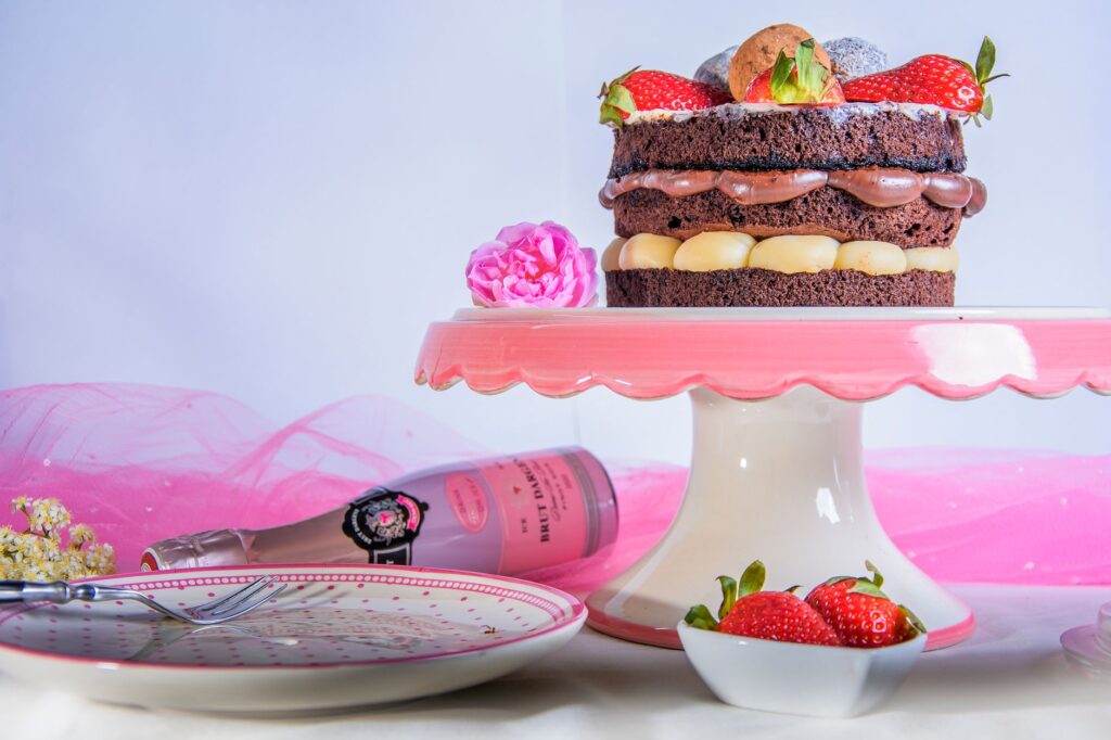 Un gâteau au chocolat élégant, garni de fraises et de champagne, parfait pour les célébrations.