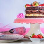 Un gâteau au chocolat élégant, garni de fraises et de champagne, parfait pour les célébrations.