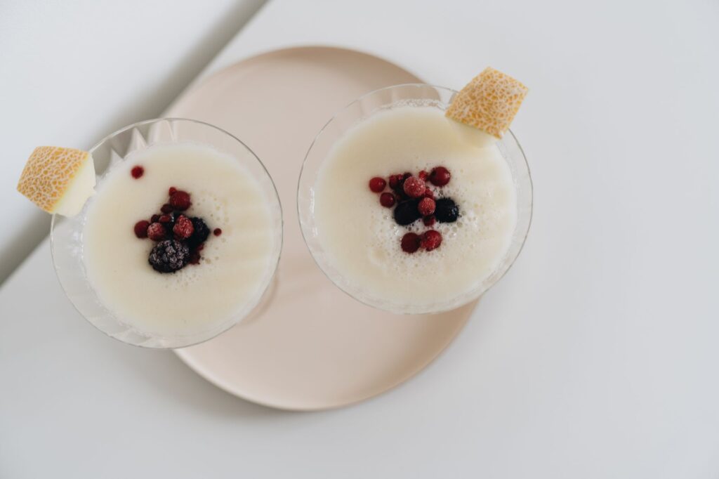 Deux smoothies crémeux garnis de baies fraîches et d'une tranche de melon, parfaits pour une indulgence saine.