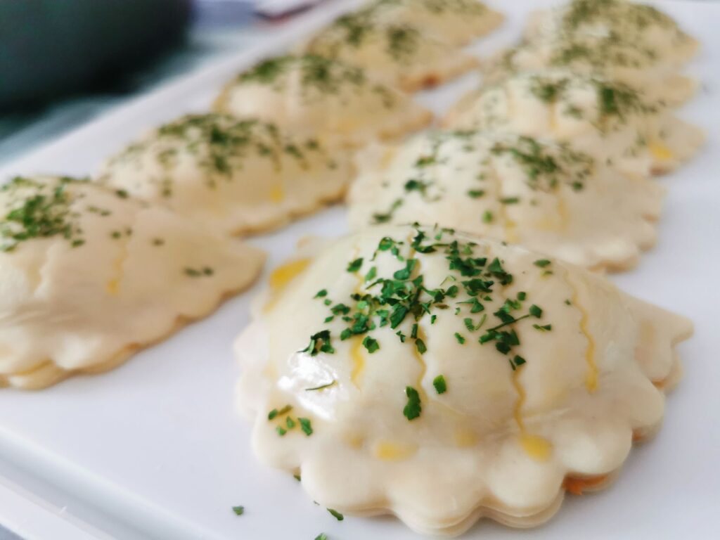 Délicieux raviolis faits maison saupoudrés de persil frais, prêts à être servis.