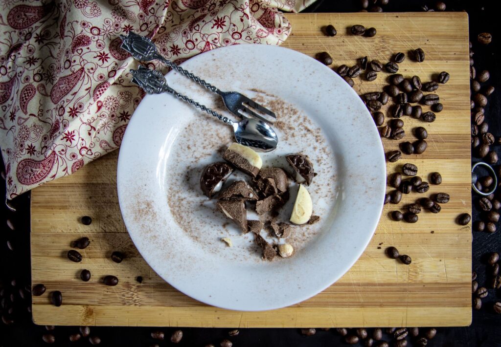 Affichage artistique d'un dessert au chocolat avec des grains de café sur une planche en bois en vue de dessus.