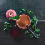 Une vue plongeante d'un smoothie sain à la pomme et à la betterave, garni de feuilles de menthe, parfait pour une détox et pour se rafraîchir.