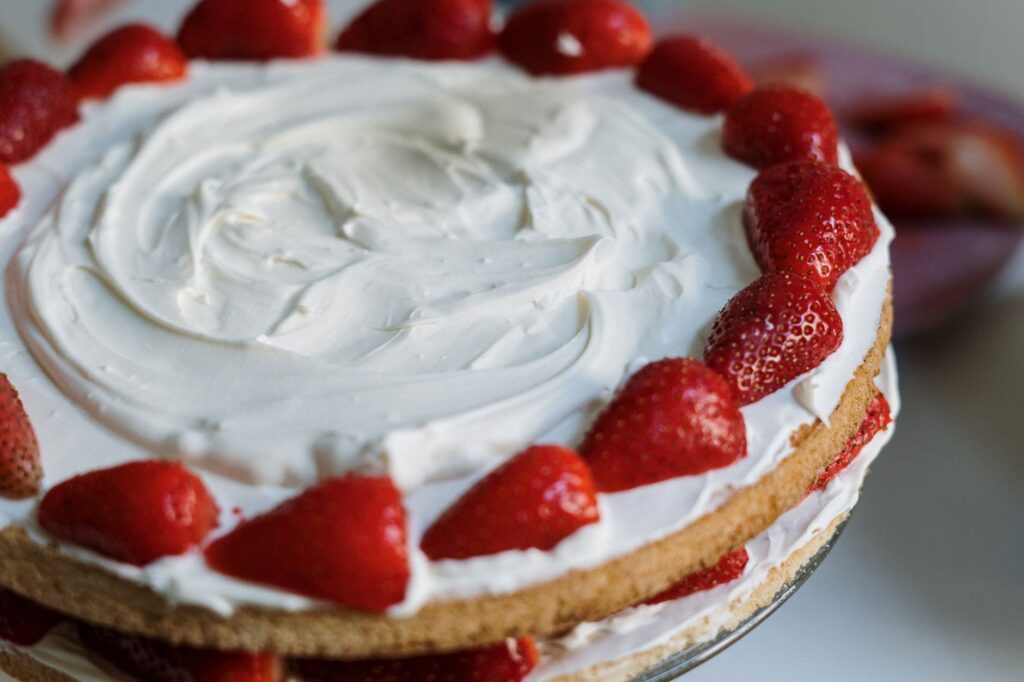 Gâteau à la crème de fraises avec des garnitures fraîches, parfait pour les amateurs de desserts.