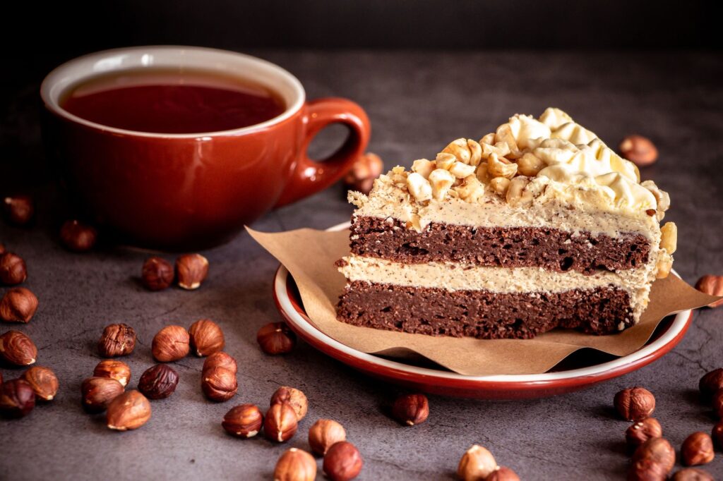 Une délicieuse part de gâteau au chocolat et aux noisettes servie avec une tasse de thé.