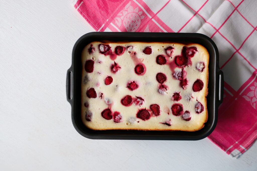 Délicieuse tarte aux framboises fait maison dans un plat de cuisson sur un tissu à carreaux.