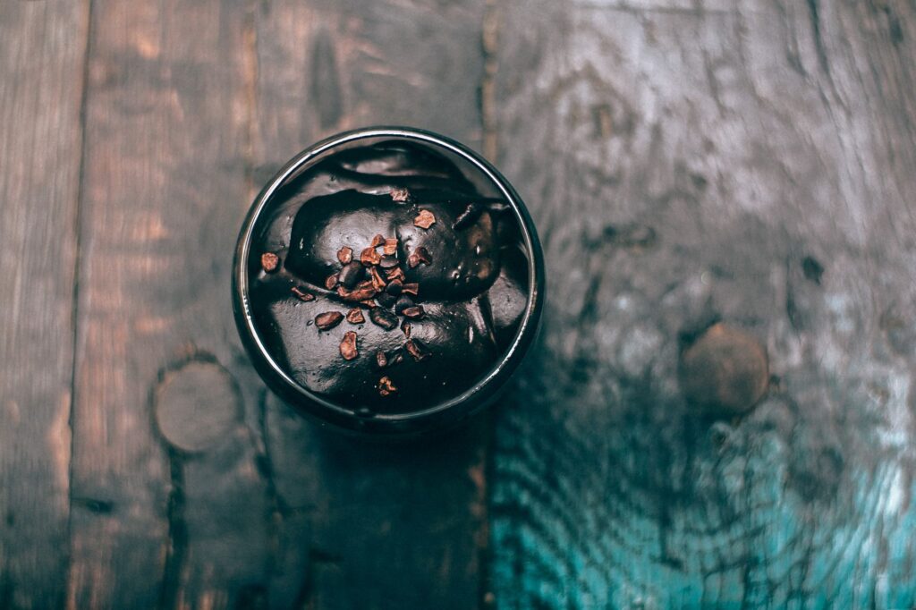 Vue de dessus de mousse au chocolat avec des éclats de cacao dans un bol rustique.