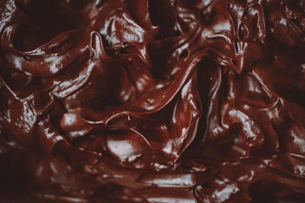 Gros plan sur une ganache au chocolat décadente et veloutée, montrant sa texture riche.