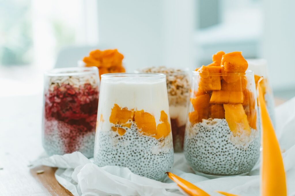 Délicieux parfaits de pudding de chia garnis de fruits frais et vibrants ainsi que de yaourt.
