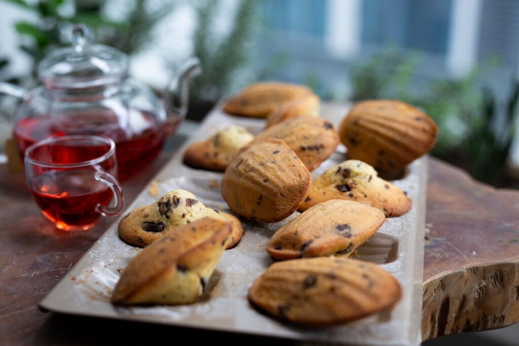 Savourez des madeleines au chocolat fraîchement cuites, accompagnées d'un thé aux herbes pour un délice.