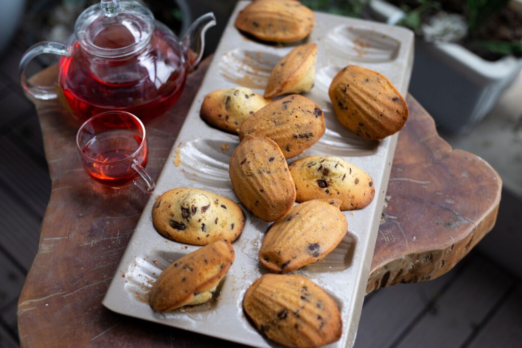 Savourez des madeleines aux pépites de chocolat fraîchement cuites avec une tasse de thé aux herbes. Parfait pour un moment de collation cosy.