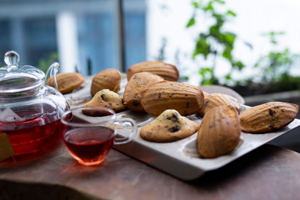 Des madeleines chaudes accompagnées d'un thé frais dans un cadre tranquille, parfait pour une pause cocooning.