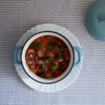 Délicieuse soupe de tomates épicée avec des herbes dans une poterie, parfaite pour des repas sains.