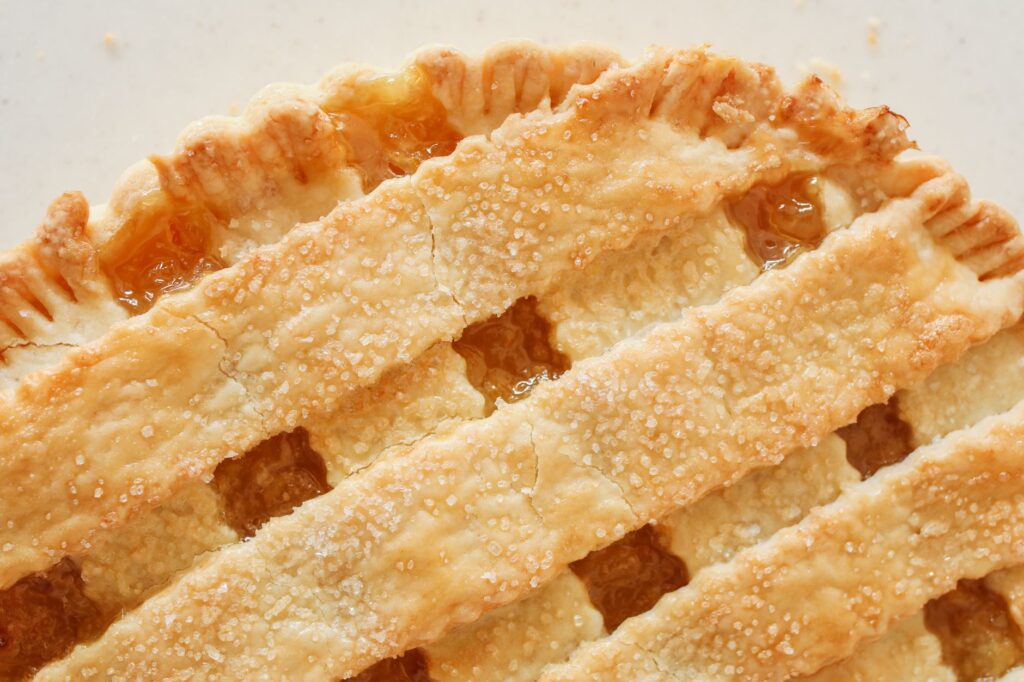Délicieuse tarte aux pommes maison avec une croûte tressée dorée, parfaite pour les amateurs de dessert.