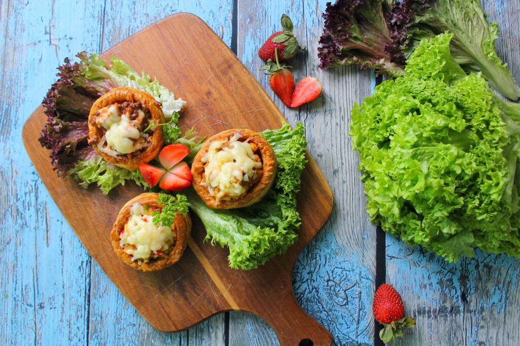 Vue du dessus de tartes cuites sur une planche en bois avec de la laitue fraîche et des fraises. Parfait apéritif gourmet.